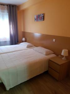 a hotel room with two beds and a window at Hostal La Pared in Torres de la Alameda