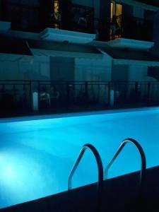 a swimming pool at night with blue lights at Hotel Alexandra in Skala