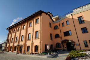 a large yellow building with a roof at Hotel La Cartiera in Vignola
