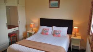 1 dormitorio con 1 cama blanca grande y 2 lámparas en Quilty Holiday Cottages - Type A en Quilty