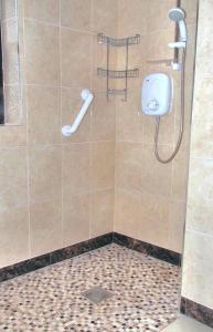a shower with a shower head in a bathroom at Quilty Holiday Cottages - Type A in Quilty