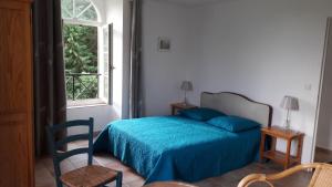 ein Schlafzimmer mit einem blauen Bett und einem Fenster in der Unterkunft Gîte Le Moulin de la Chaussee in Saint-Denis-dʼOrques