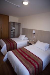A bed or beds in a room at Hotel Prisma Cusco