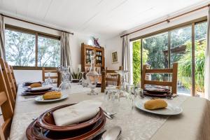ein Esszimmer mit einem Tisch mit Tellern und Küchenutensilien in der Unterkunft Villa Can Llamas in Pollença