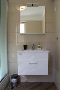 a bathroom with a white sink and a mirror at Apartmani Marin in Vrbnik