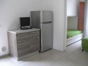 a room with a refrigerator and a tv on a dresser at Residence I Pini in Capoliveri