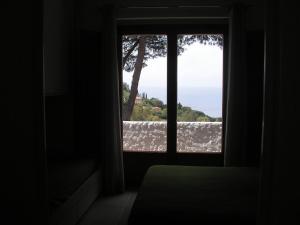 a room with a window looking out at the ocean at Residence I Pini in Capoliveri