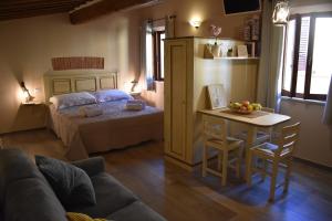Sala de estar con cama y mesa con un bol de fruta en La Casa del Buonumore, en Montepulciano