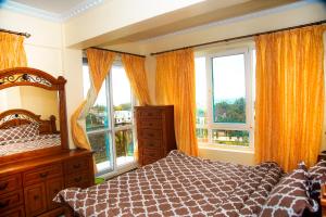 a bedroom with a bed and two windows at Luxury Apartment with Ocean View in Oyster Bay in Dar es Salaam +125 photos