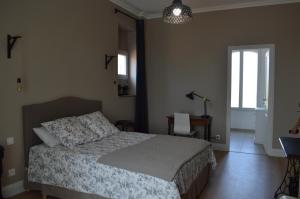 um quarto com uma cama e uma janela em La maison d'Antoine Rivesaltes em Rivesaltes