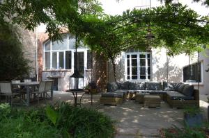 een patio met een bank en een tafel voor een huis bij La maison d'Antoine Rivesaltes in Rivesaltes