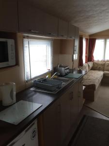 a kitchen with a counter top and a living room at Beach walk in Mablethorpe