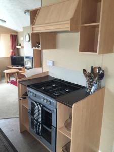 a kitchen with a stove top oven in a room at Beach walk in Mablethorpe