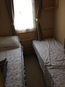 two beds in a small room with a window at Beach walk in Mablethorpe
