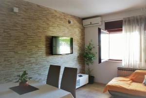 sala de estar con mesa de comedor y pared de ladrillo en Apartments Villa Judita, en Blace