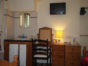 a bathroom with a sink and a desk with a mirror at Bodhyfryd Guesthouse in Betws-y-coed