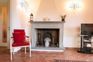 een woonkamer met een open haard en een rode stoel bij Appartamento Gregorio in Montespertoli