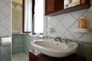 y baño con lavabo blanco y espejo. en Appartamento Mariolu, en Santa Maria Navarrese