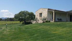 a stone house in a field of grass at B&B Majore in Olbia