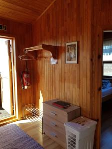 una camera da letto con pareti in legno, un letto e un comò di Ekra Cottages a Lagarfljótsvirkjun