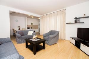 ein Wohnzimmer mit Sofa, Sesseln und Fernseher in der Unterkunft Apartment Jusepe in Trogir