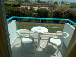 a white table and two chairs on a balcony at Leonidas Hotel & Studios in Kos