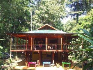 a large wooden house with a deck in the woods at El Tucan Jungle Lodge in Puerto Viejo +19 photos