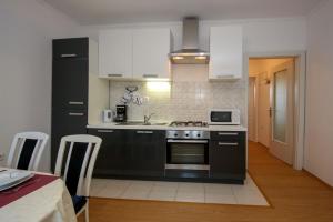 eine Küche mit schwarzen und weißen Geräten und einem Tisch in der Unterkunft Apartment Nakić in Vrpolje