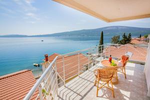 a balcony with a table and chairs and a view of the water at Boka Apartmani in Bijela