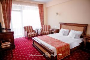 Richmond Hotel في مامايا: غرفة فندقية بسرير وطاولة وكراسي