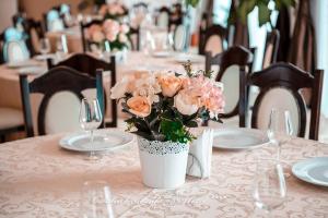 une table avec un vase de fleurs sur une table avec des verres dans l'établissement Richmond Hotel, à Mamaia