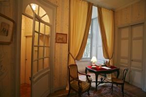 a room with a table and chairs and a window at Château de Beaujeu in Sens-Beaujeu