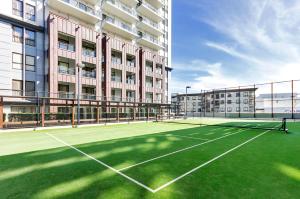 a tennis court in front of a building at Heritage Luxury & Viaduct Vibe in Auckland