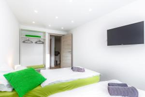 a bedroom with two beds and a flat screen tv at Apartments In The City in Rijeka