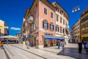 a group of people walking on a street in a city at Apartments In The City in Rijeka