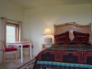 a bedroom with a bed and a table and a lamp at Lodgepole Gallery in Browning