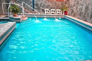 a swimming pool with chairs in the water at Termas Del Sol in Termas de Río Hondo