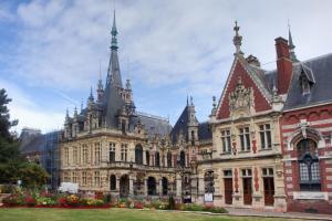 um edifício ornamentado com torres por cima em Gites de mer Les Boucanes em Fécamp