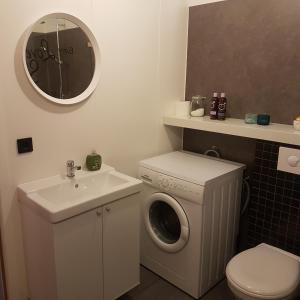 uma casa de banho com uma máquina de lavar roupa e um lavatório em Hólavegur 6 em Sauðárkrókur