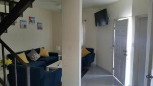 a living room with a blue couch and a television at villa serena 4 Beds, 2 Bath in Rosarito