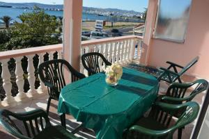 einen grünen Tisch mit Stühlen und eine Vase mit Blumen auf dem Balkon in der Unterkunft Sea View Apartments Pericic in Sukošan