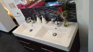 ein Waschbecken im Badezimmer mit einer Vase mit Blumen darauf in der Unterkunft Room Tereza in Zadar + 18 Fotos
