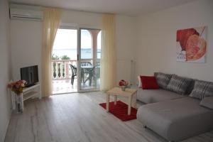 ein Wohnzimmer mit einer Couch und einem Tisch in der Unterkunft Sea View Apartments Pericic in Sukošan