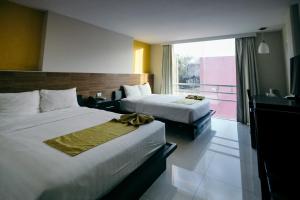 a hotel room with two beds and a balcony at Hotel El Español Paseo de Montejo in Mérida