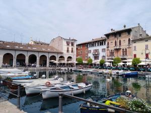 eine Gruppe von Booten, die in einem Kanal mit Gebäuden angedockt sind in der Unterkunft Appartamento zia Cecilia in Desenzano del Garda