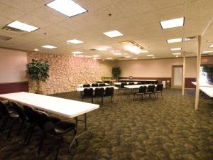 una sala de conferencias con mesas y sillas. en Lamplighter Inn-South, en Springfield
