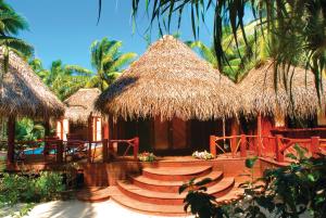 a resort with a deck and a thatch roof at Aitutaki Lagoon Private Island Resort (Adults Only) in Arutanga