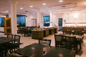 um restaurante com mesas e cadeiras e um bar em Hotel Plaza Mayor em Santo André