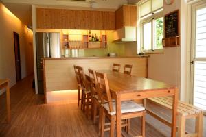 a kitchen with a wooden table and chairs at Taiori House in Jiaoxi