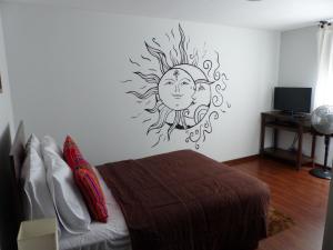 1 dormitorio con un dibujo del sol en la pared en The Lighthouse Bed and Breakfast, en Lima